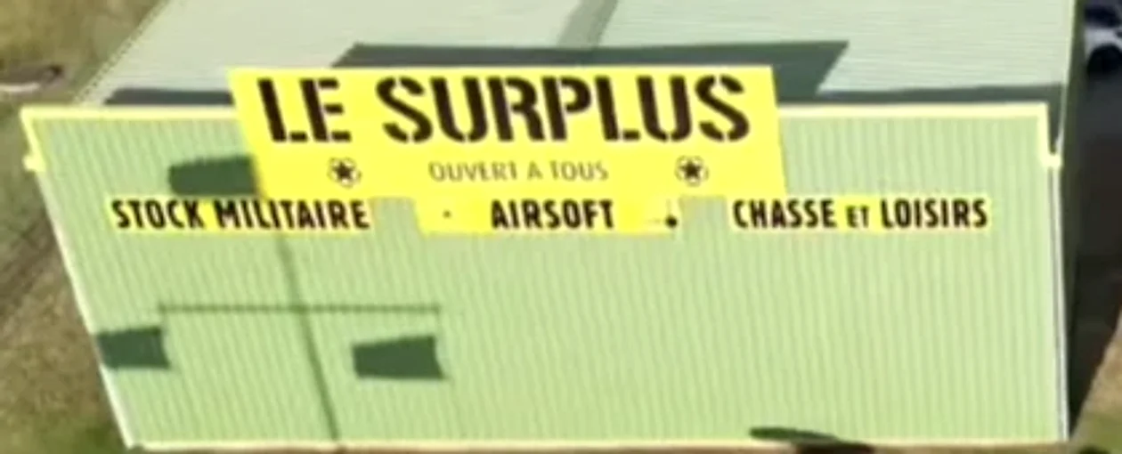 L'enseigne jaune Le Surplus : stock militaire, airsoft, chasse et loisirs
